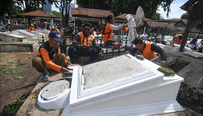 Sejumlah petugas DKRTH Surabaya melakukan pengecatan makam kuno Belanda di kawasan Peneleh Surabaya, Selasa 10 Maret 2020. (Foto: Erfan Hazransyah/Ngopibareng.id)