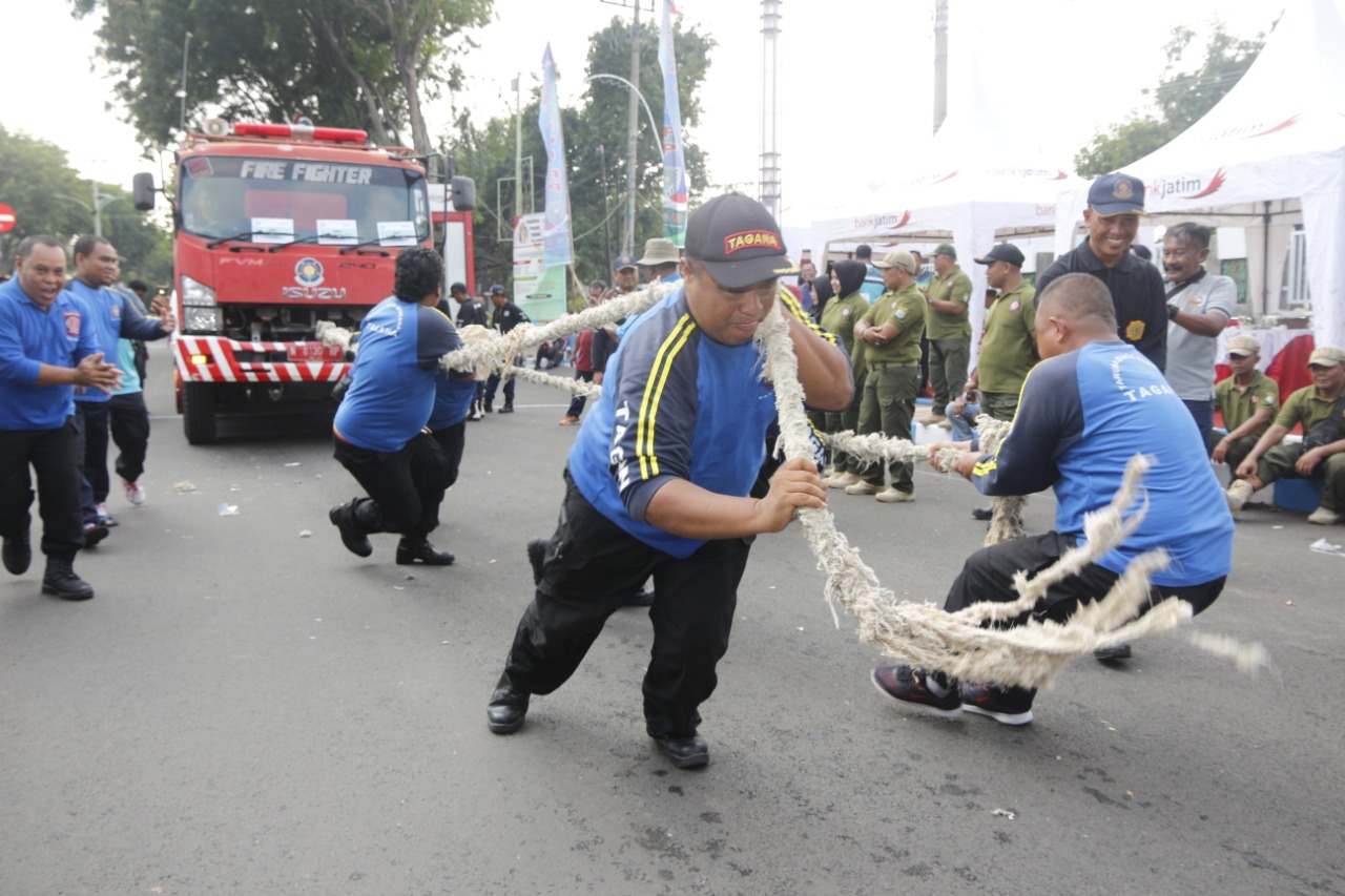 Salah satu tim berusaha keras menarik mobil pemadam kebakaran (Damkar) di Kota Probolinggo. (Foto: Ikhsan Mahmudi/Ngopibareng.id)