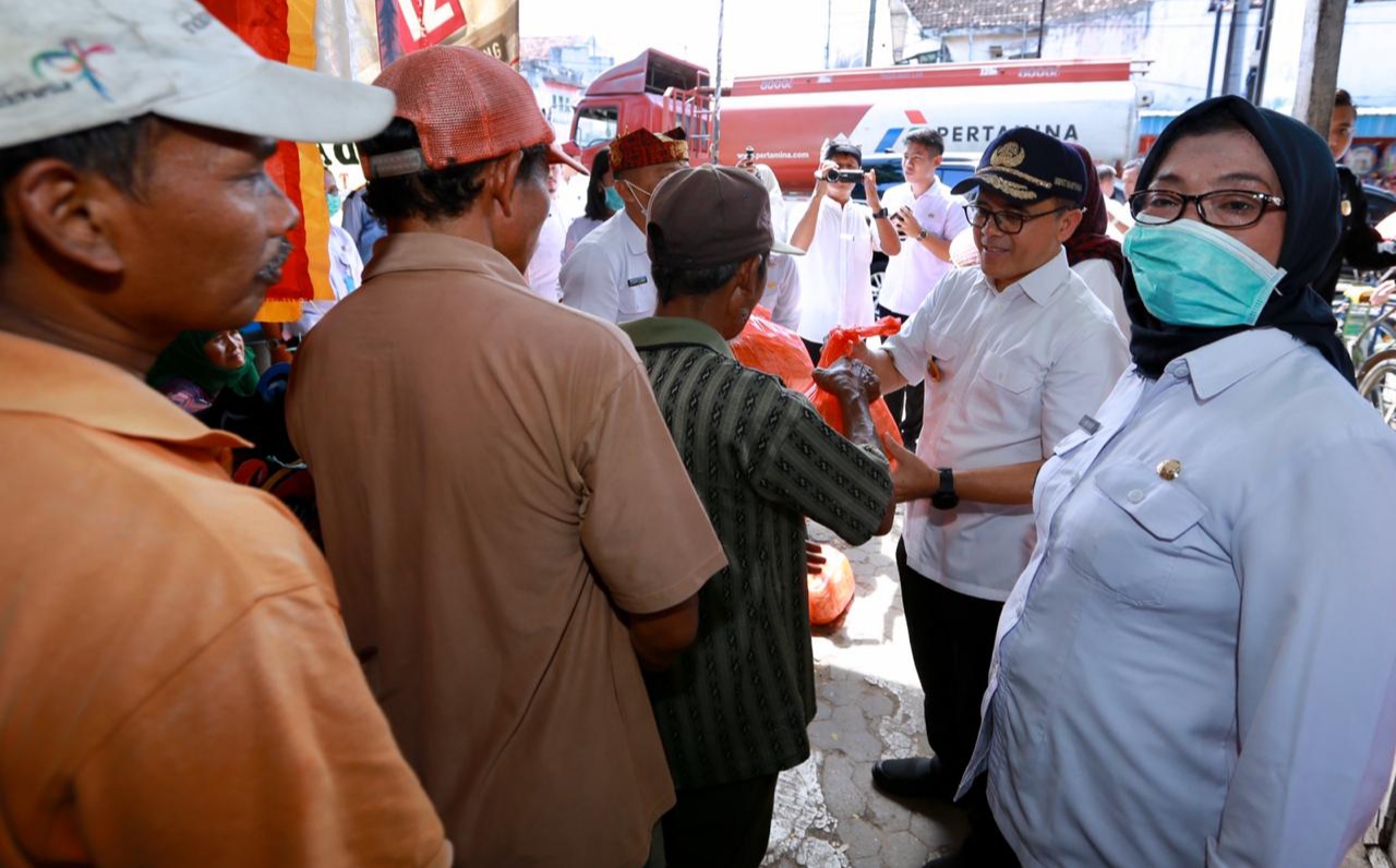 Bupati Banyuwangi Abdullah Azwar Anas menyerahkan bantuan sembako pada tukang becak (foto:istimewa)