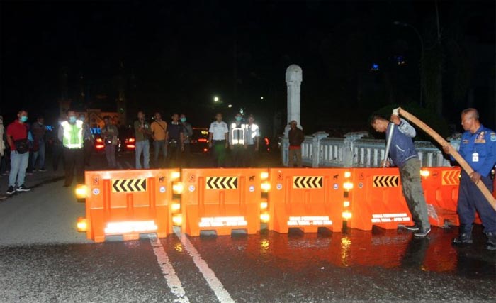 Petugas melakukan pengalihan jalur saat penutupan sebagian jalan protokol Kota Tegal, Jawa Tengah, Senin dini hari. Pemerintah Kota Tegal dan Polres Tegal hingga 14 hari mendatang melakukan 