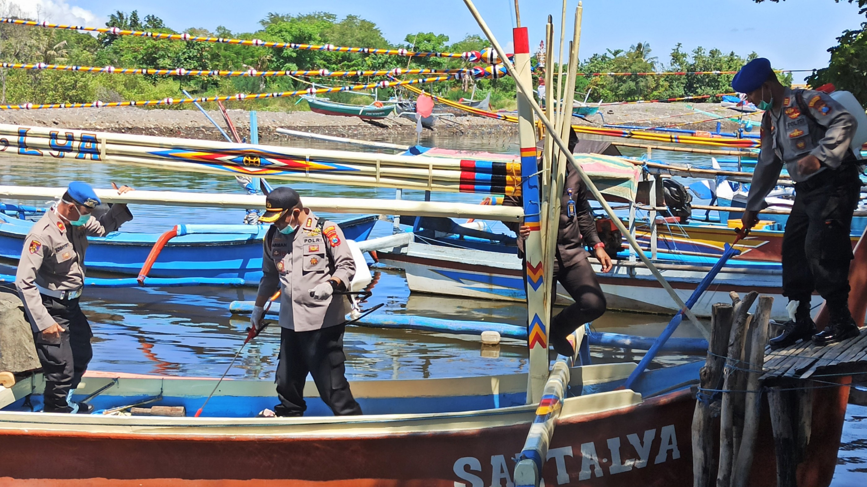 Kapolresta Banyuwangi Kombespol Arman Asmara Syarifuddin turut melakukan penyemprotan disinfektan pada kapal nelayan di Kampung Mandar. (Foto: Istimewa)