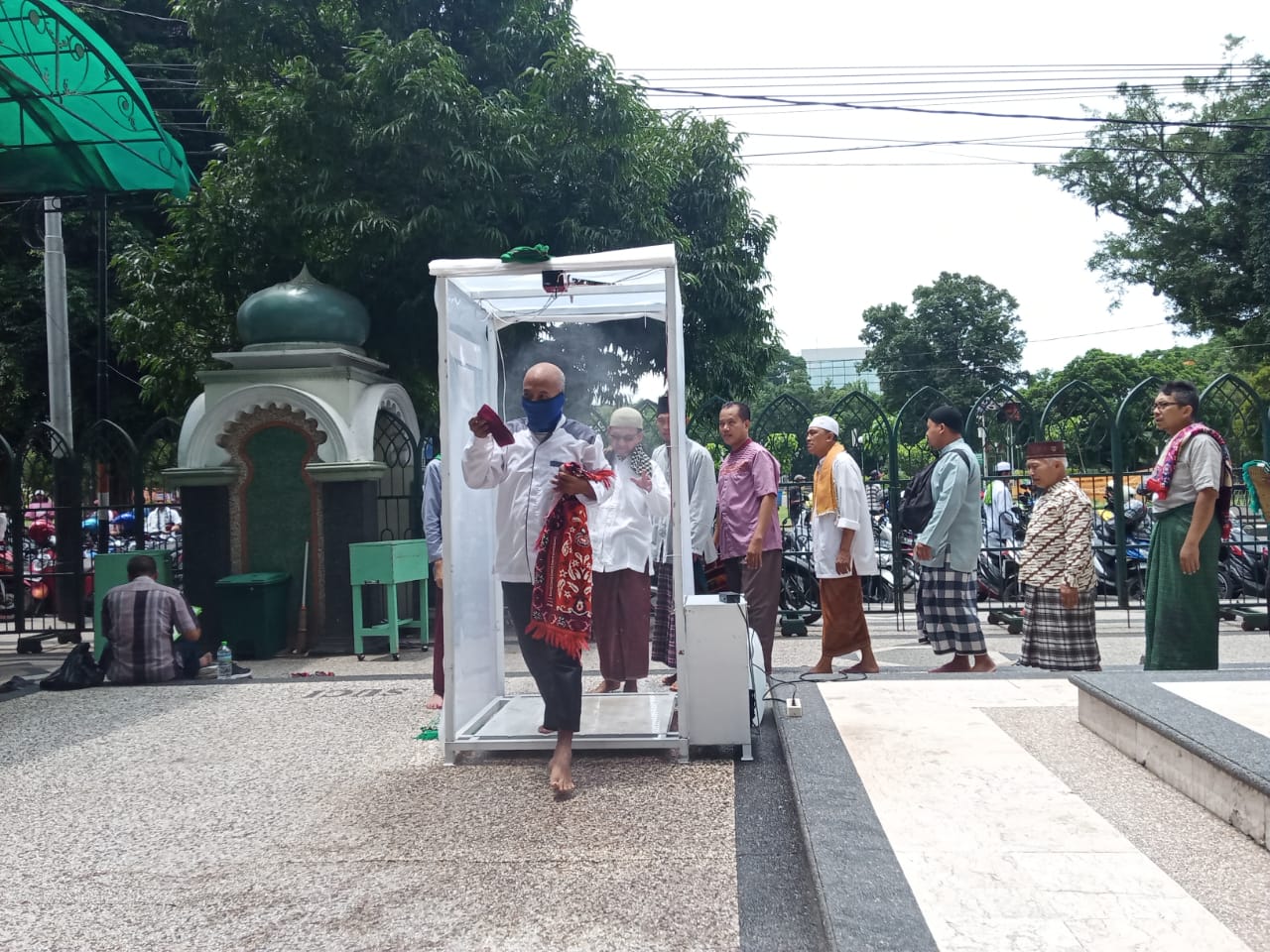 Jemaah shalat Jumat di Masjid Jami'Kota Malang saat disemprotkan desinfektan (Foto: Lalu Theo/ngopibareng.id)