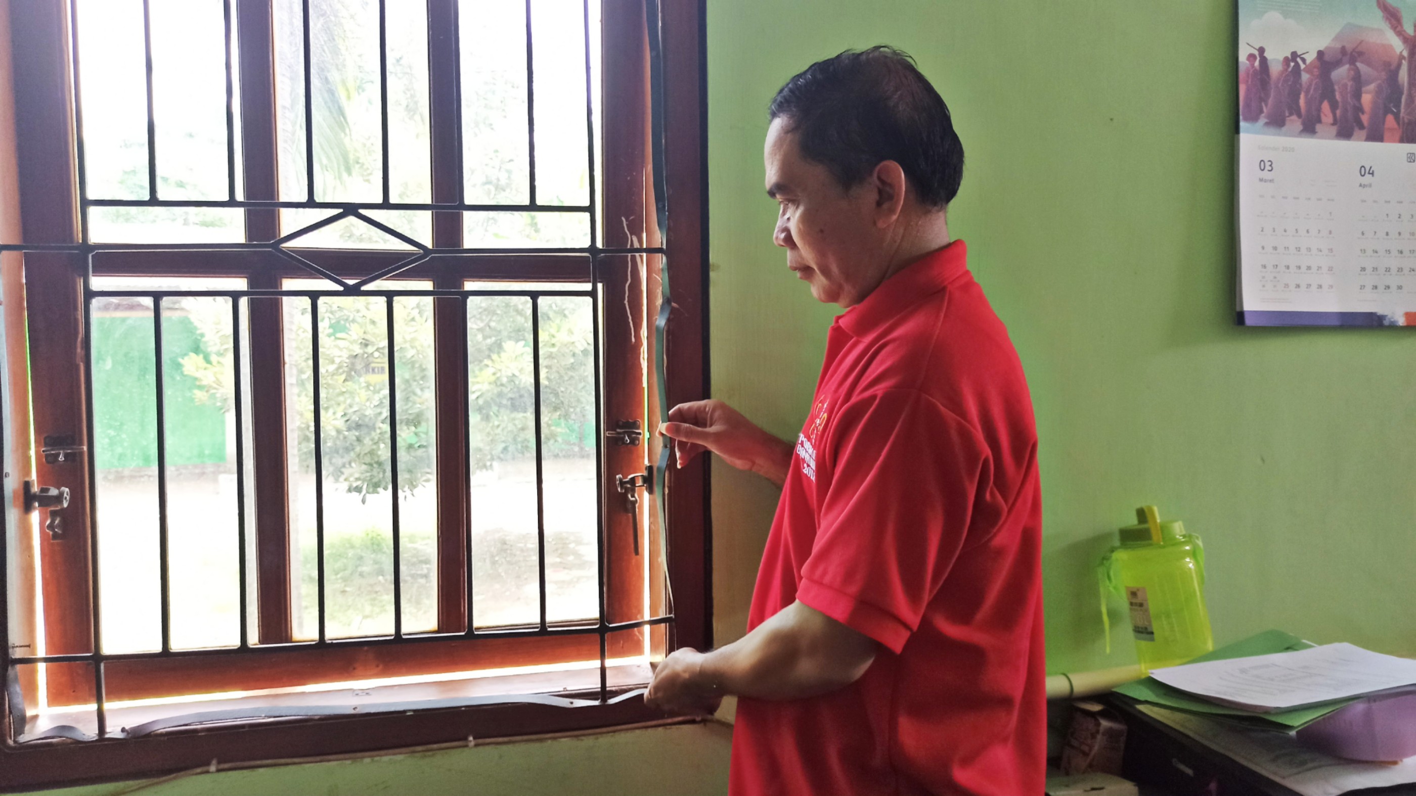 Kepala Korwilker Satdik Kecamatan Glagah, Janoto menunjukkan teralis besi yang rusak (Foto: Hujaini/Ngopibareng.id)