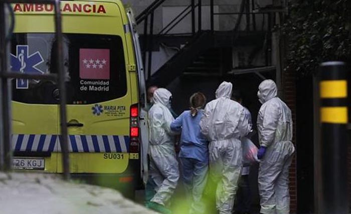 Petugas kesehatan menurunkan pasien  dari mobil ambulan ke sebuah hotel di Madrid, Spanyol,  yang telah dijadikan rumah sakit, kemarin. (Foto:Reuters)