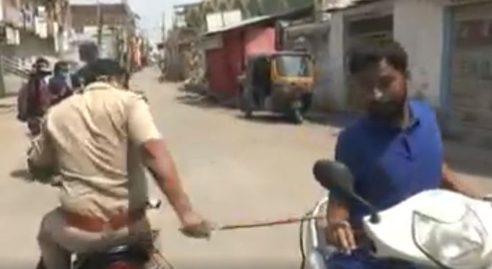 Salah seorang pengendara motor kena sabetan tongkat oknum polisi India. (Foto: Facebook)