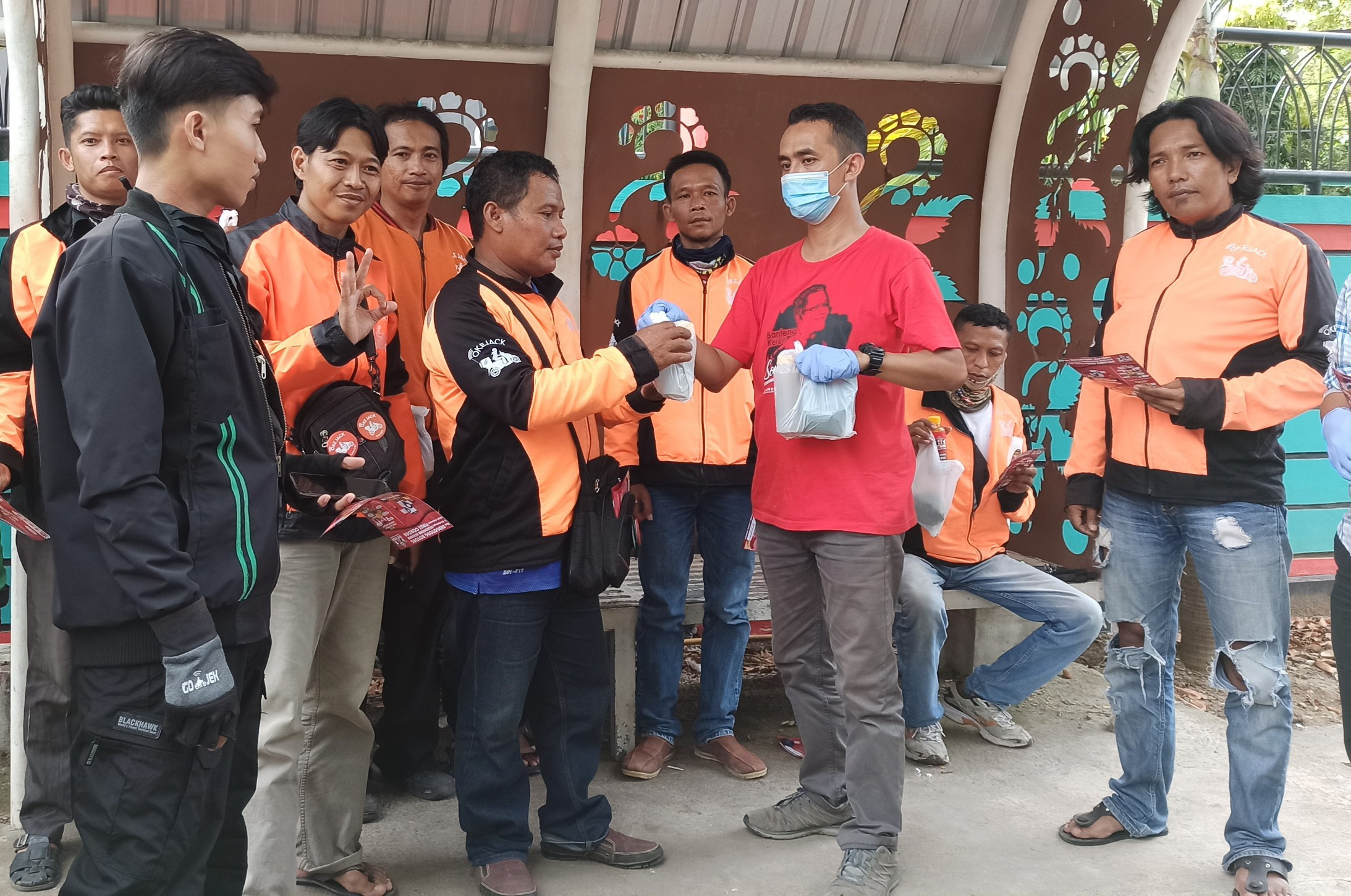 Komunitas Rumah De Giri menyerahkan bantuan pada sejumlah pengemudi ojek online atau ojol. (Foto: Muh Hujaini/Ngopibareng.id)