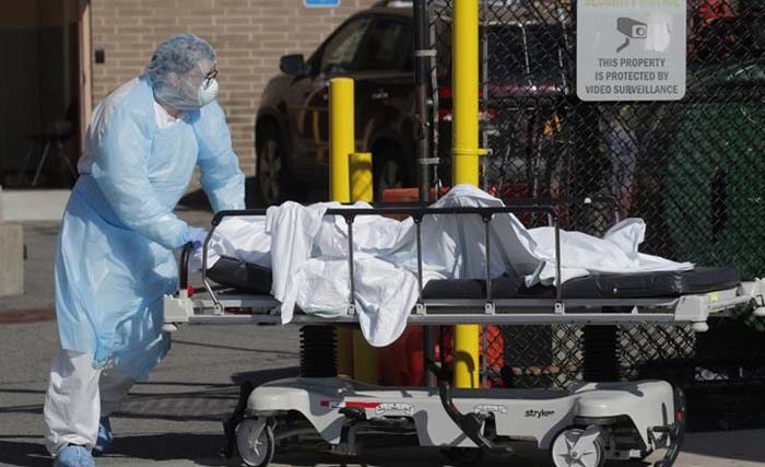 Seorang petugas kesehatan mendorong jenazah korban COVID-19 di  Wyckoff Heights Medical Center,  di wilayah Brooklyn di Kota New York, AS, kemarin. (Foto:Reuters)