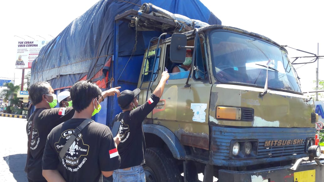 Komunitas sopir truk membagikan masker gratis pada sopir truk yang melintas di Pelabuhan Ketapang, Banyuwangi, Jawa Timur. (Foto: Istimewa)
