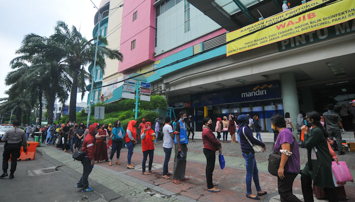 Pemilik dan pegawai toko di Pusat Grosir Surabaya (PGS) tampak antri untuk masuk kedalam PGS. (foto : Erfan Haransyah/ngopibareng.id)