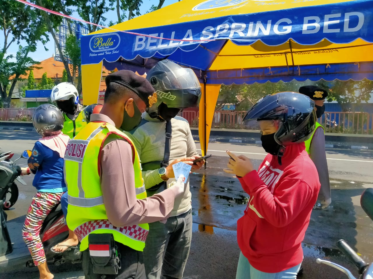 Anggota Kepolisian memeriksa identitas pengendara yang melanggar aturan PSBB di cek poin Waru, Sidoarjo, Jumat 1 Mei 2020. (Foto: Fariz Yarbo/Ngopibareng.id)