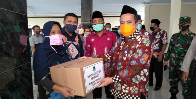 Wabup Pasuruan KH Mujib Imron saat menyerahkan bantuan paket sembako di Balai Desa Karangjati, Kecamatan Pandaan, kemarin siang. (Foto: Dok HUmas
