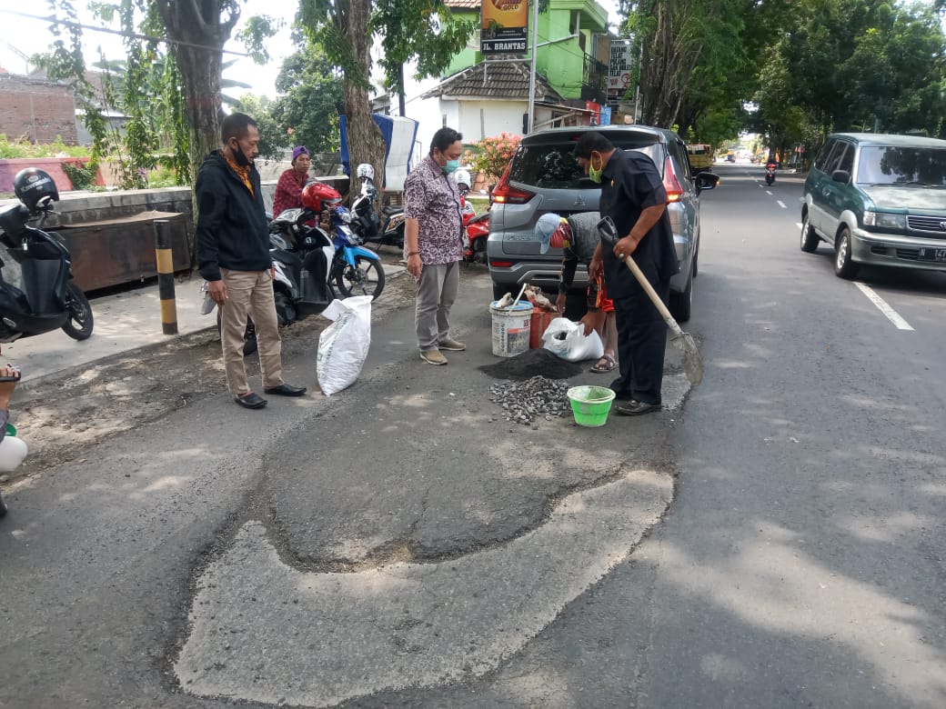Anggota Komisi III DPRD Kota Probolinggo perbaiki Jalan Brantas yang berlubang. (Foto: Ikhsan Mahmudi/ngopibareng.id)