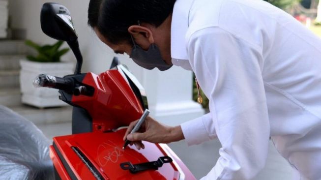 Presiden Joko Widodo saat menandatangani Gesits Motor Listrik yang dilelang. (Foto: Antara)