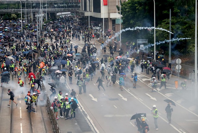 Para demonstran tak gentar meski ditembakkan gas air mata oleh petugas kepolisian. (Foto: AFP)