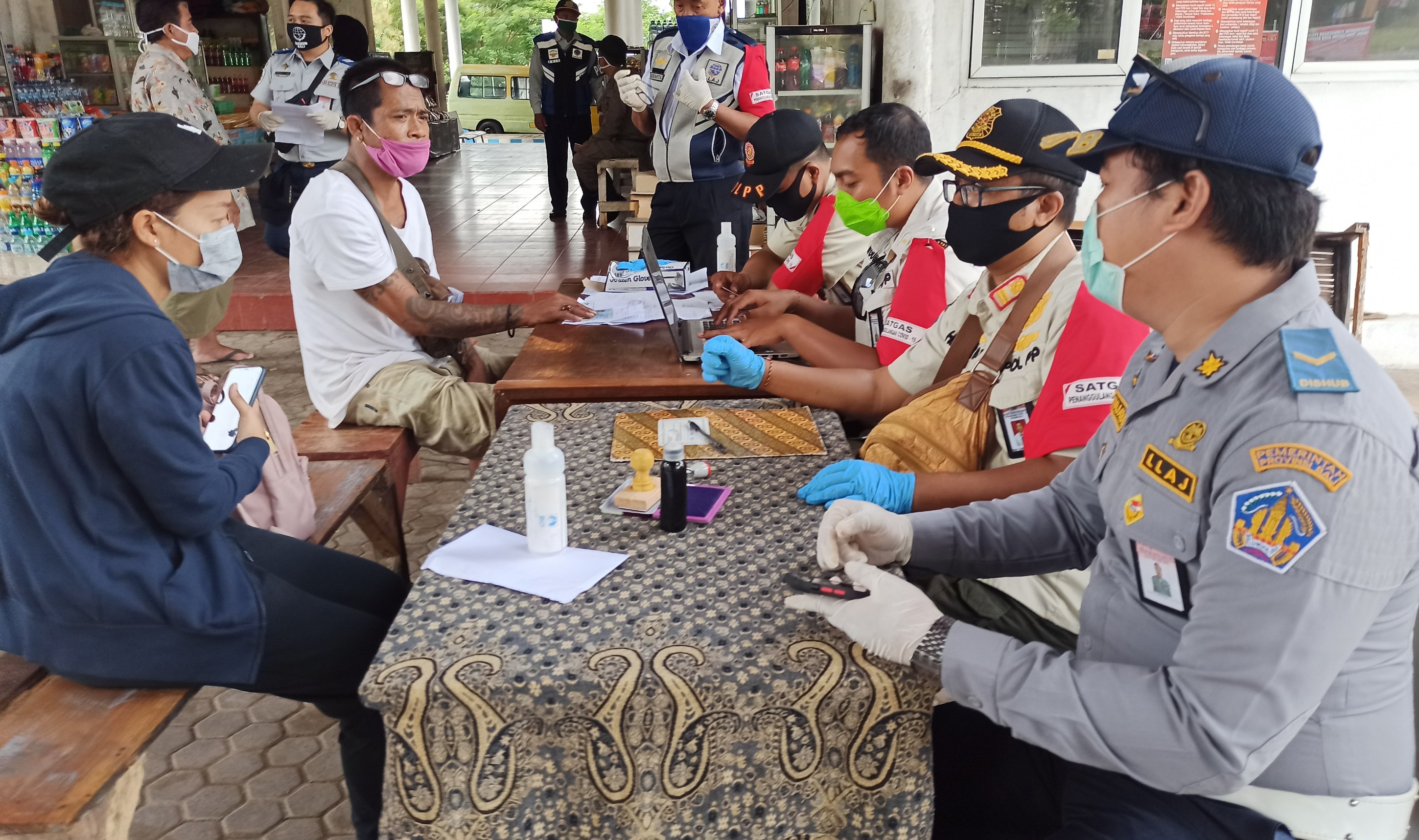 Petugas GTPP Covid-19 Provinsi Bali melakukan pendataan pada warga yang akan menyeberang ke Bali di check point Terminal Sritanjung, Banyuwangi, Jawa Timur. (Foto: Muh Hujaini/Ngopibareng.id)