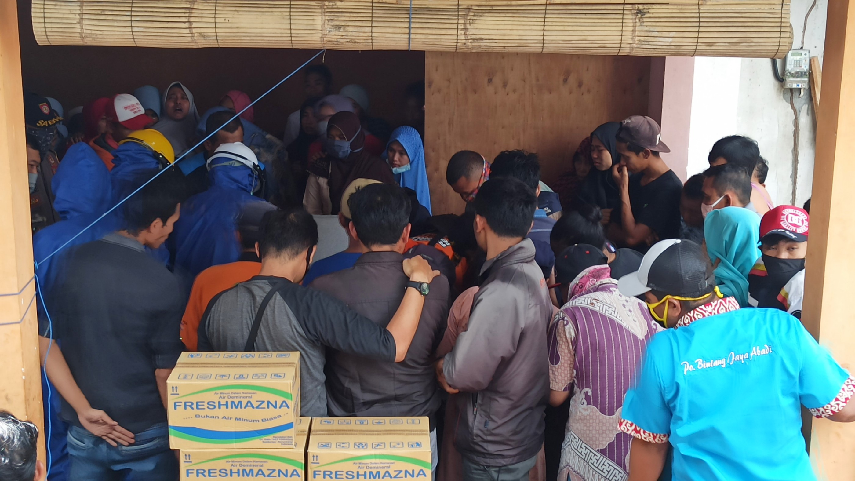 Warga dan keluarga korban mengelilingi jenazah korban yang disemayamkan di rumah keluarganya di Desa Tamansari, Kecamatan Licin (foto: Hujaini/ngopibareng.id)