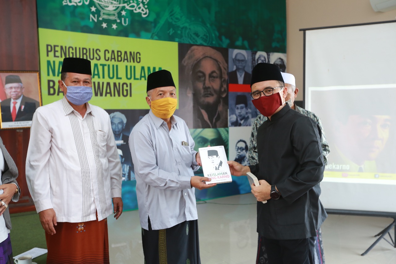 Bupati Banyuwangi Abdullah Azwar Anas menyerahkan buku kepada Wakil Rais Syuriah KH Abdul Ghofar di kantor PCNU Banyuwangi (foto:istimewa)l