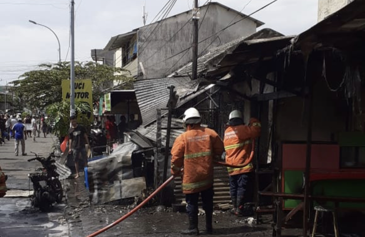 Tim PMK saat menangani kios bensin yang terbakar. (Foto: Dinas PMK Surabaya)