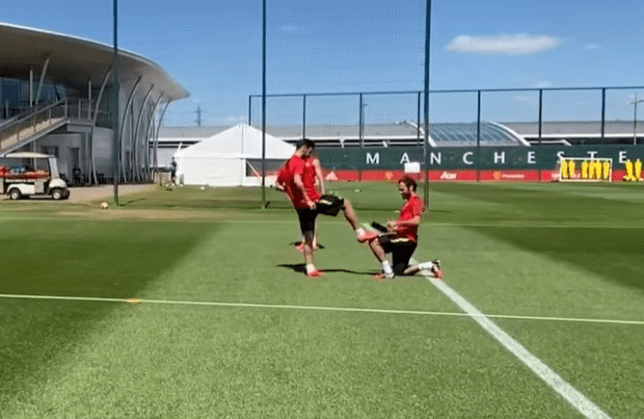 Juan Mata saat 'menyemir' sepatu Bruno Fernandes. (Foto: Man Utd/Tangkapan Layar Youtube)