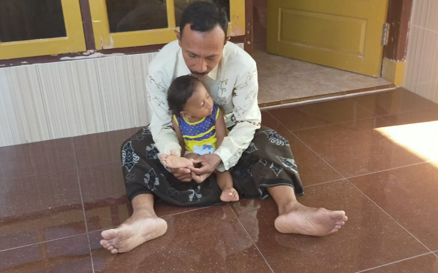 Nur Yasin menunjukkan bekas ruam pada tubuh anaknya (foto: istimewa)