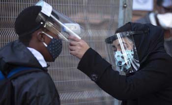 Seorang murid dicek suhunya sebelum masuk kelas di sekolah Kota Cape Town, Afrika Selatan, kemarin.  (Foto:Reuters)