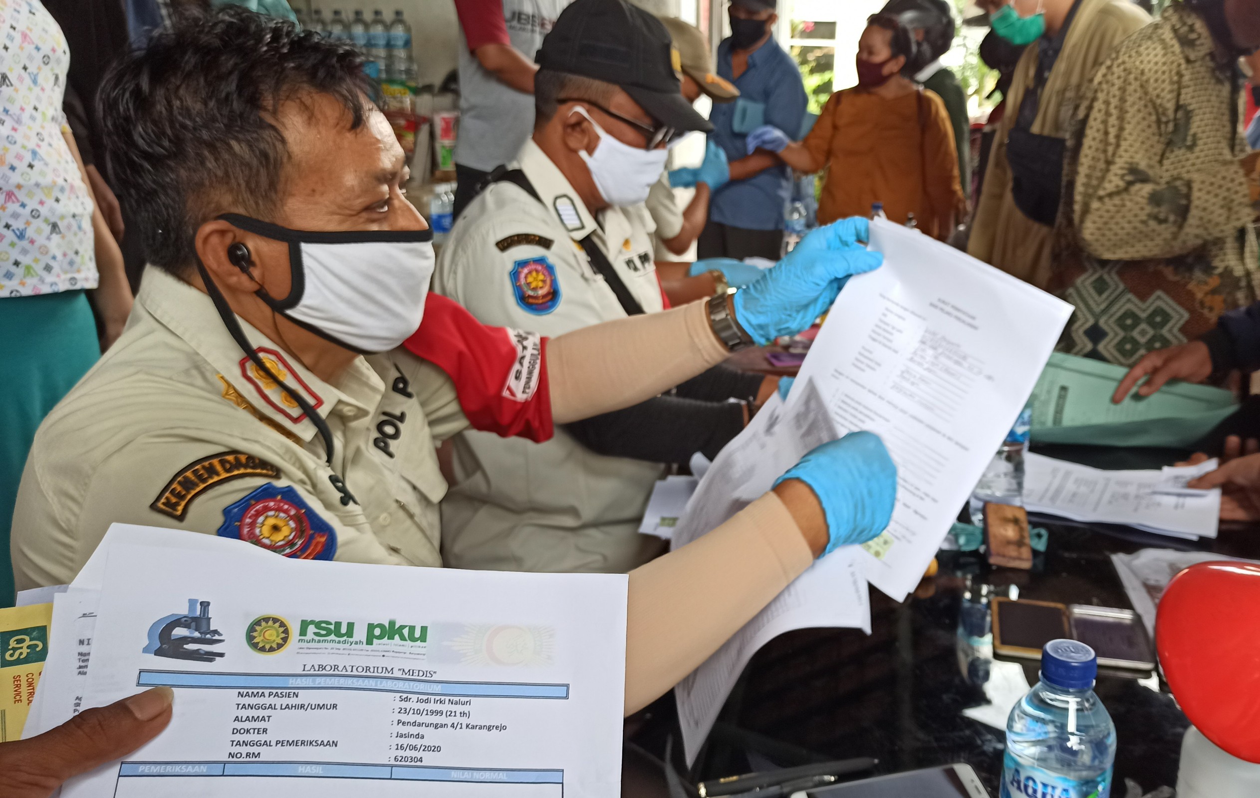 Petugas GTPP Covid-19 Provinsi Bali sedang mengecek dokumen persyaratan di check point Terminal Sritanjung Banyuwangi (foto: Hujaini/ngopibareng.id)