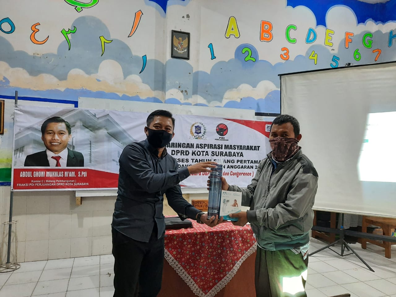 Wakil Ketua DPC PDIP Surabaya, Abdul Ghoni Mukhlas Ni'am saat menyerahkan APD ke salah satu RT Bulak. (Foto: Ni'am Kurniawan/Ngopibareng.id)