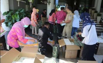 Pegawai Pemkot Surabaya segera membongkar masker bantuan dari Kota Guangzhou, China, hari Selasa. (Foto:Antara)