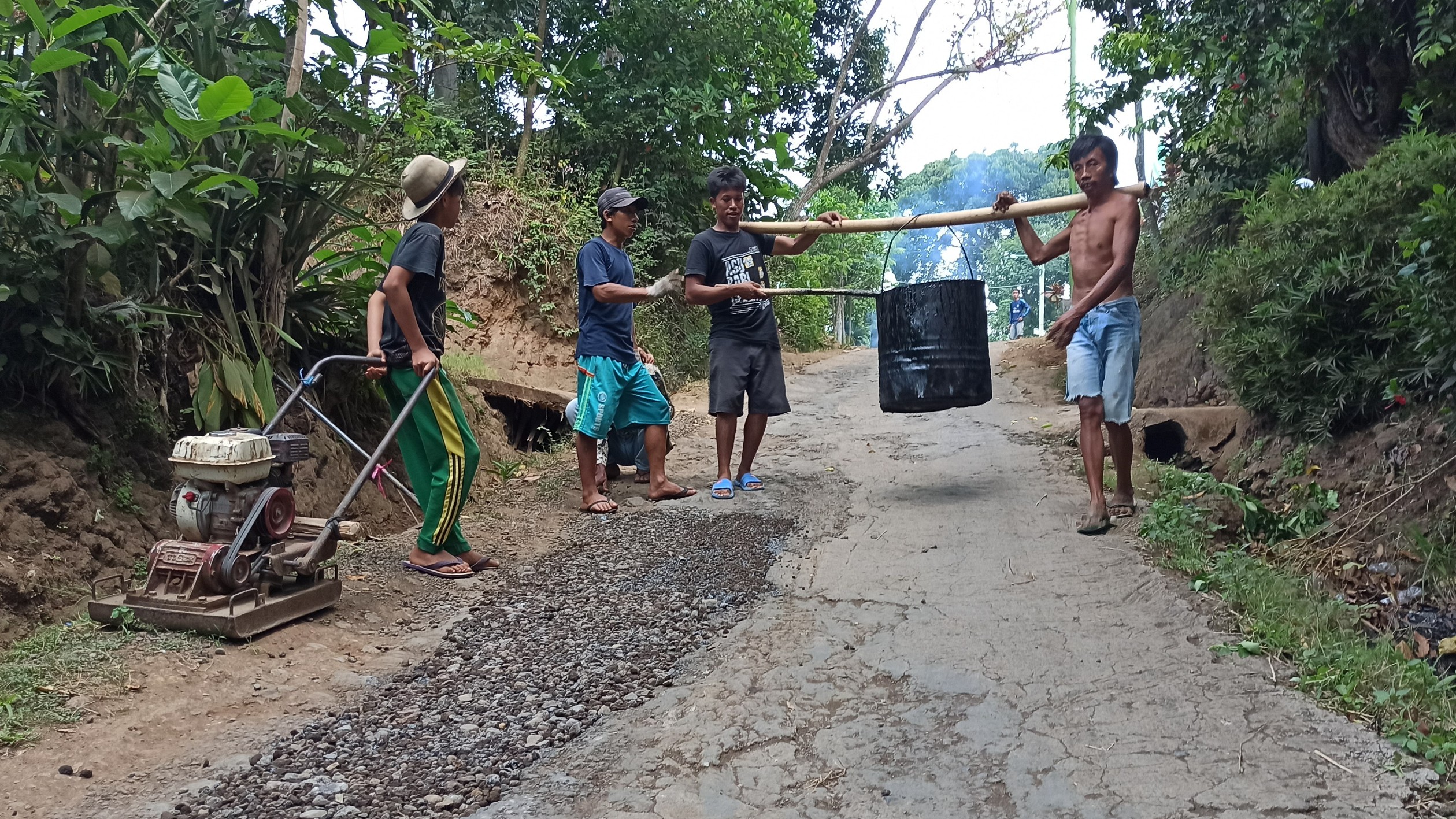 Warga lingkungan Papring, Kelurahan Kalipuro melakukan pengaspalan jalan dengan dana swadaya setiap hari Rabu. (Foto: Muh Hujaini/Ngopibareng.id)
