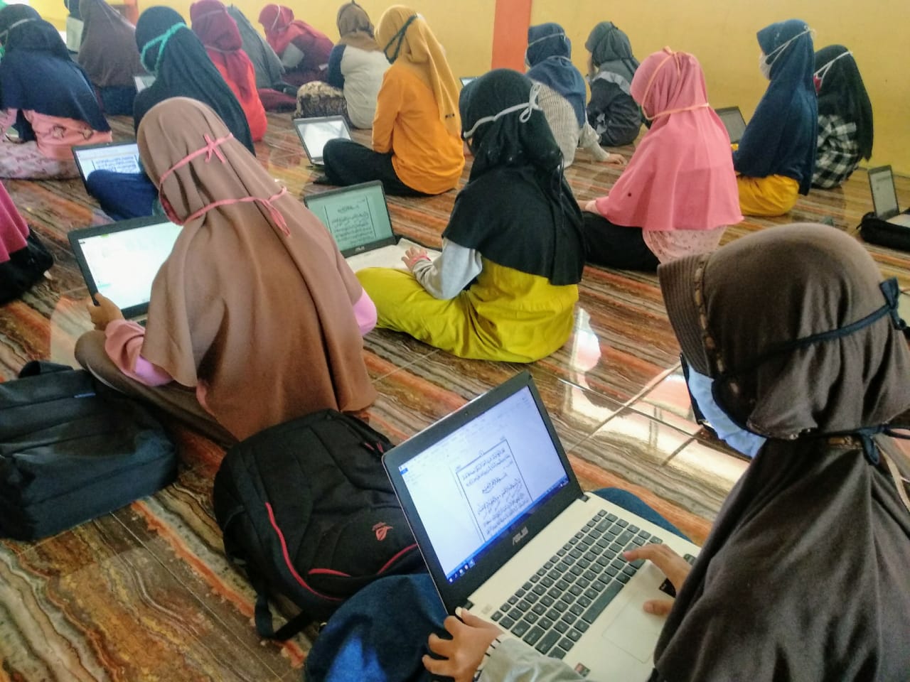 Suasana santriwati pondok Aqobah saat belajar online. Mereka menggunakan masker serta membawa laptop. (Foto: M.Rizqi/Ngopibareng.id)