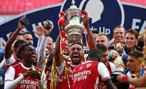 Para pemain Arsenal mengangkat trofi FA usai mengalahkan Chelsea di Stadion Wembley, Minggu dini hari. (Foto:AFP)