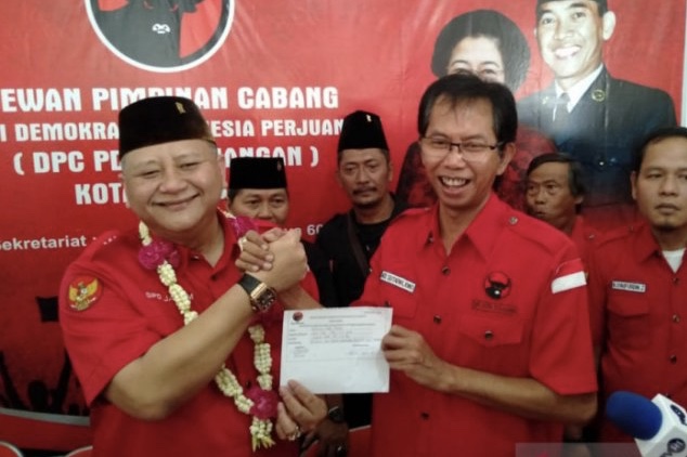 Whisnu Sakti Buana (kiri) saat menyerahkan berkas pendaftaran bakal calon walikota pada Ketua DPC PDIP Surabaya Adi Sutarwijono. (Foto: Antara)