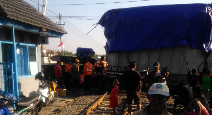 Truk trailer ‘nyangkut’ pada rel di perlintasan KA di Jrebeng Lor, Kota Probolinggo. (Foto: Ikhsan Mahmudi/ngopibareng.id)