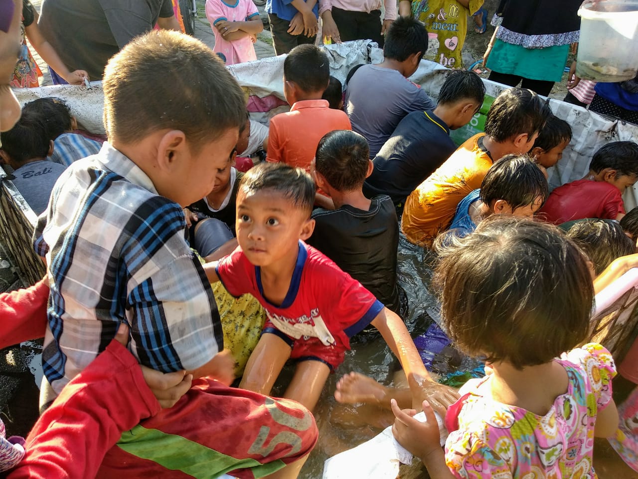 Sejumlah anak kecil asyik mengikuti lomba tangkap ikan lele di Dusun Laban, Desa Bendet, Kecamatan Diwek, Kabupaten Jombang, Senin 17 Agustus 2020. (Foto: M.Rizqi/Ngopibareng.id)
