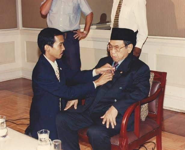 Presiden KH Abdurrahman Wahid ketika memasang dasi, dibantu ajudannya. (Foto: Istimewa)