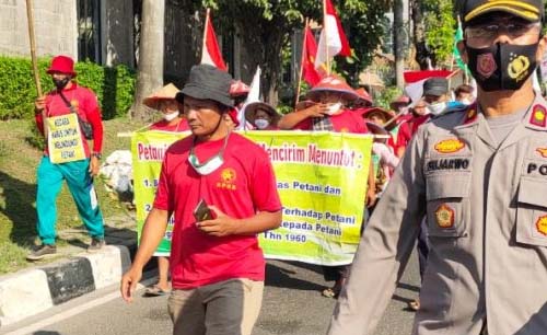 Sebanyak 170 petani dari Deli Serdang, Sumatera Utara berjalan menuju istana dengan kawalan polisi, Selasa siang. (Foto:Antara)