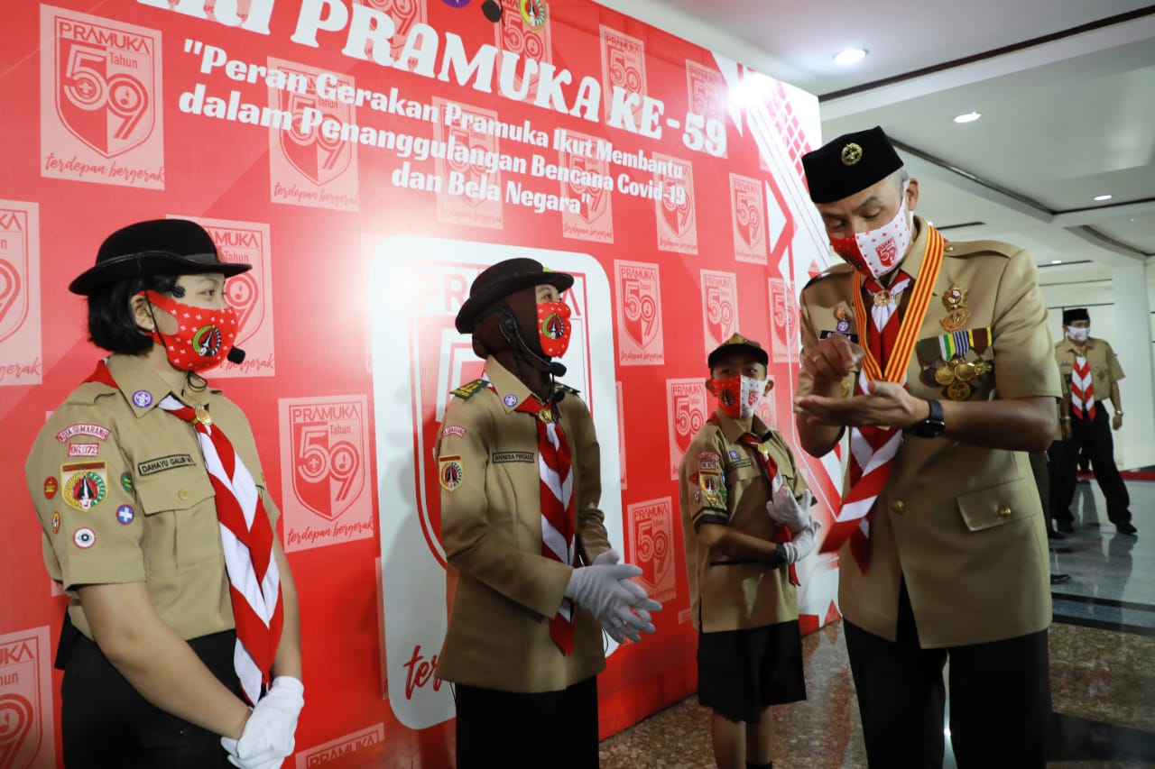 Gubernur Jawa Tengah Ganjar Pranowo saat memberikan bantuan kain untuk Pramuka. (Foto: Ist/Ngopibareng.id)
