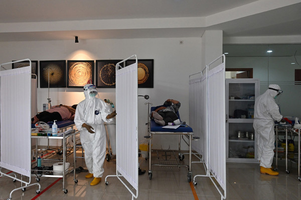 Dokter Carissa Putri (kiri)  dan perawat Vincensia Vista menangani pasien Covid di ruang isolasi Covid 19 di Tangerang. (ADEK BERRY-AFP/Disway.com)