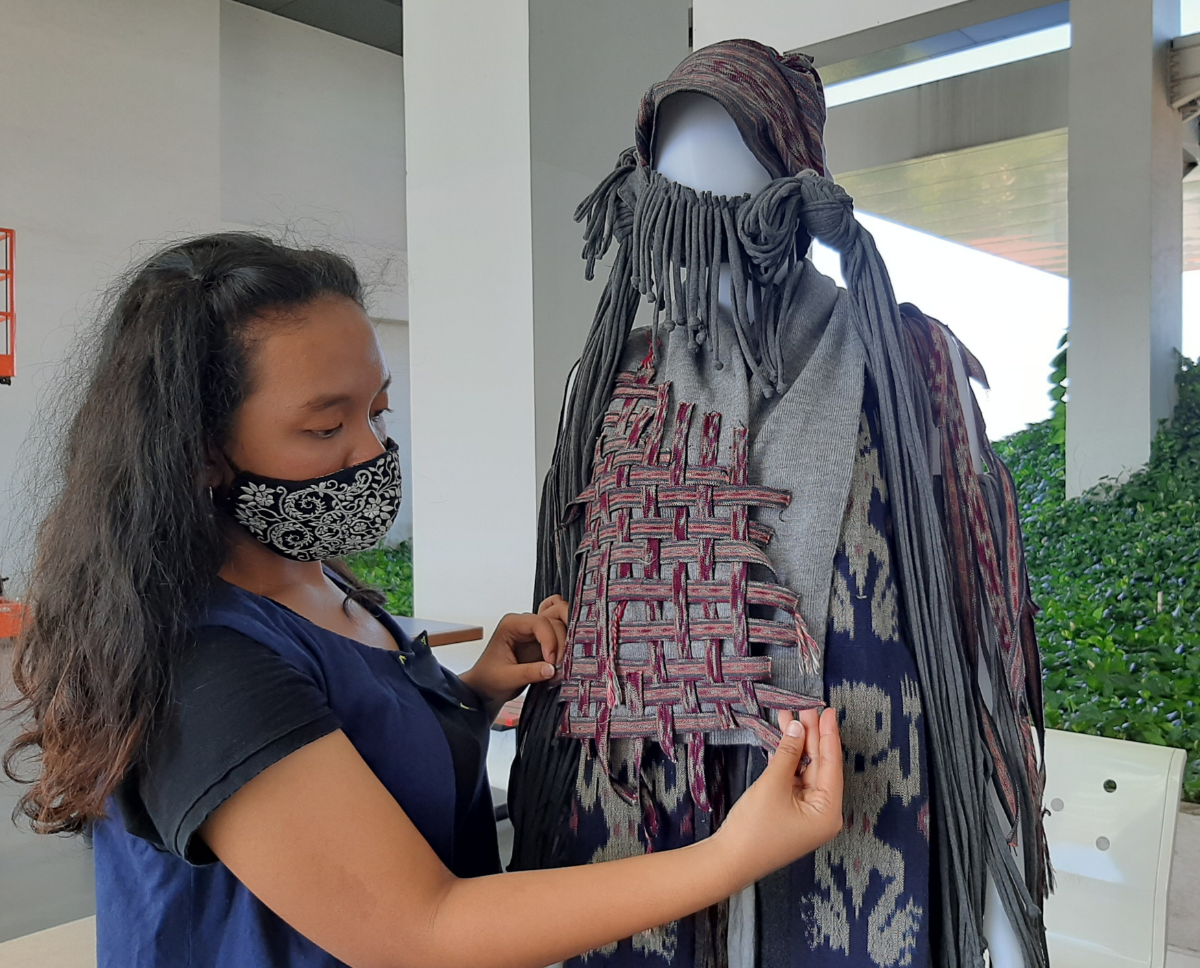 Auke Kurnia Septianingrum saat merapikan baju hasil karyanya yang diberi nama Sustainable Dysto-Tenun War. (Foto: Pita Sari/Ngopibareng.id)