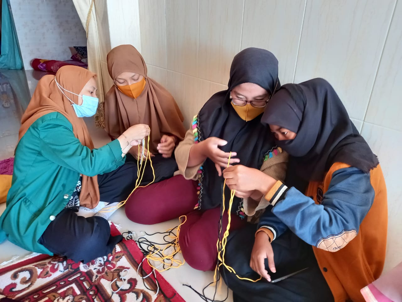 Mahasiswa Universitas Nahdlatul Ulama Surabaya (Unusa) saat memberikan pelatihan kerajinan dari tali kur kepada warga Sidoarjo. (Foto: Istimewa)