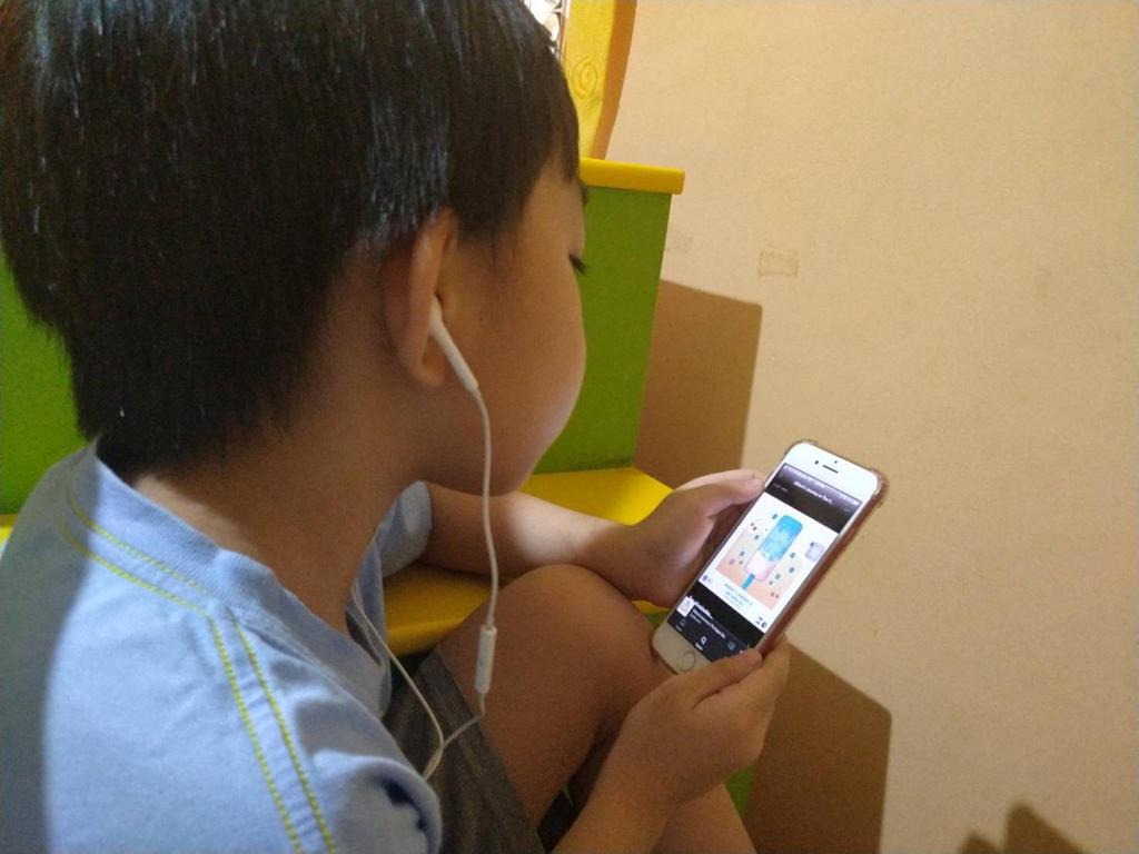 Seorang bocah laki-laki sedang mendengarkan SPELLBOUND, yang dilakukan tim dosen UK Petra. (Foto: Istimewa)