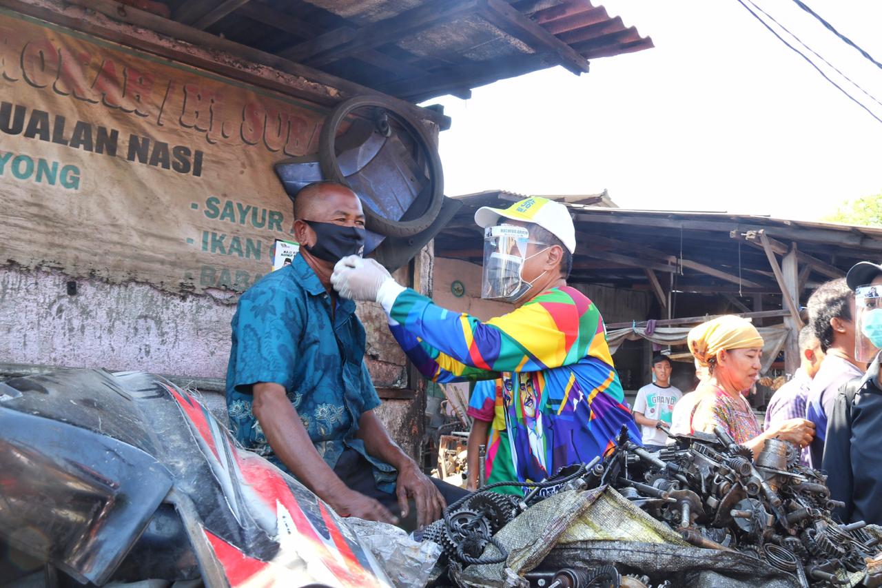 Bakal calon Wakil Walikota Surabaya, Mujiaman Sukirno memasangkan masker kepada pedagang di Pasar Loak Dupak Rukun, Surabaya, Sabtu 12 September 2020. (Foto: Istimewa)