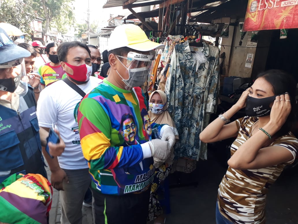 Bacawawali Surabaya, Mujiaman Sukirno ketika membagikan masker kepada pedagang di Pasar Simo, Surabaya, Selasa 15 September 2020. 