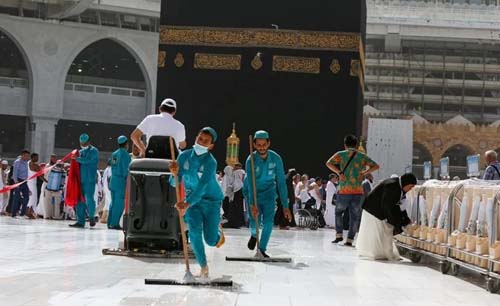 Petugas kebersihan memakai masker saat memberishkan lantai Masjidil Haram di kota Makkah, Arab Saudi, Senin lalu. Arab Saudi akan buka kembali Umrah secara bertahap mulai 4 Oktober mendatang. (Foto:ArabNews)