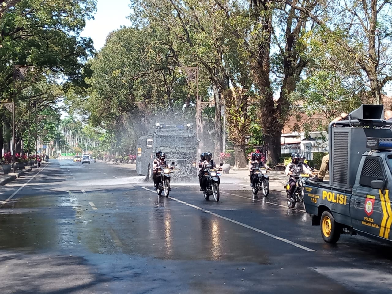 Mobil Armoured Water Canon Polresta Malang Kota saat menyemprotkan cairan disinfektan (Foto: Lalu Theo/Ngopibareng.id)