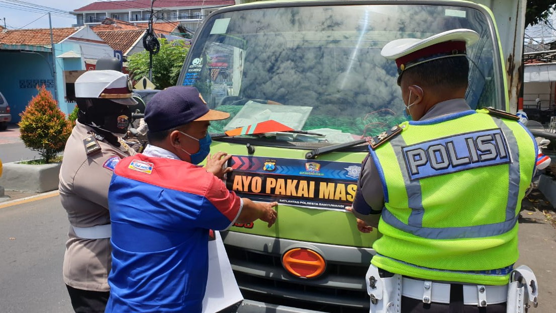 Polantas memasang stiker 'Ayo Pakai Masker' pada sebuah truk boks (foto:Istimewa)