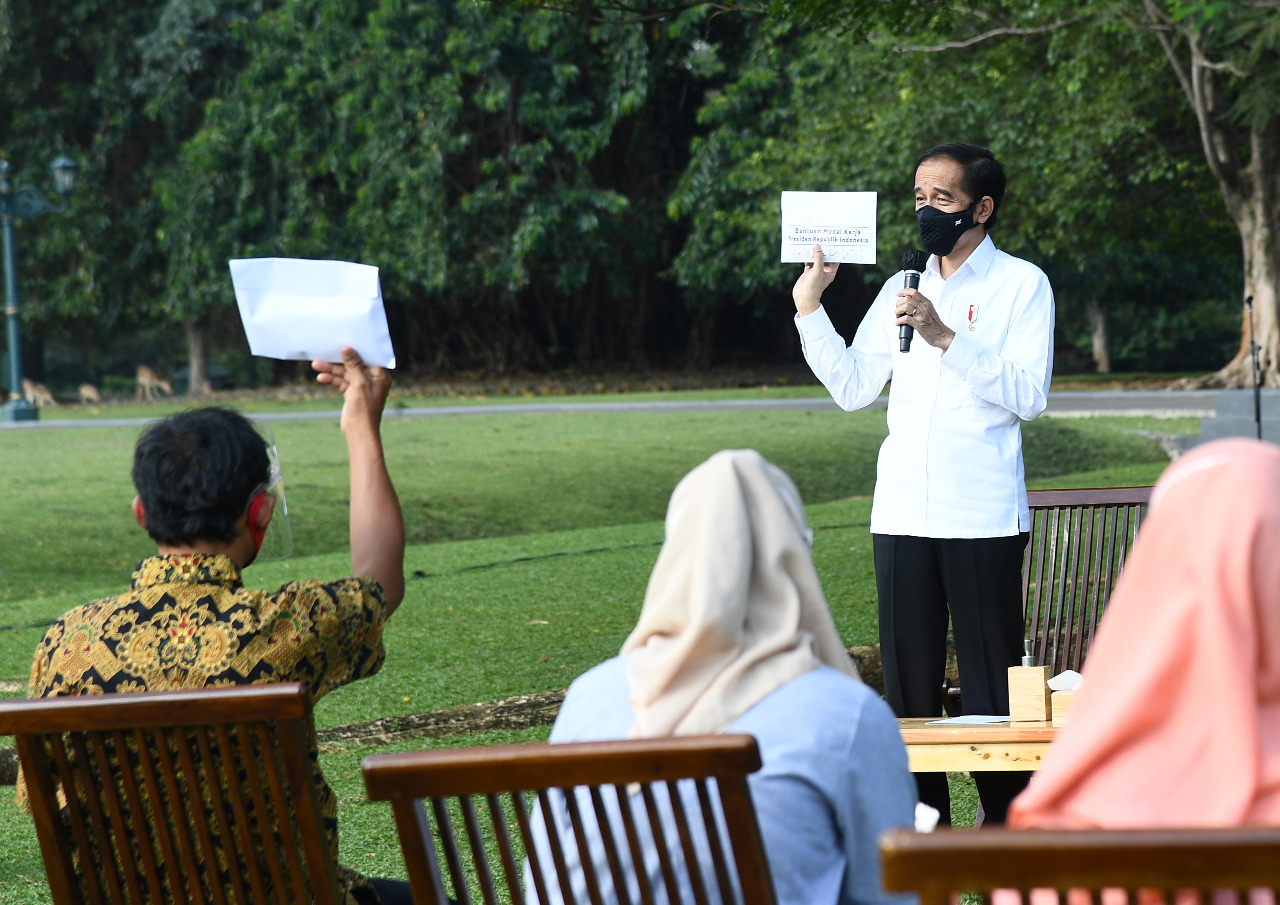 Presiden Joko Widodo membagikan modal kerja bagi terdampak pandemi Covid-19  di lapangan terbuka Istana Bogor. ( Foto: Setpres)