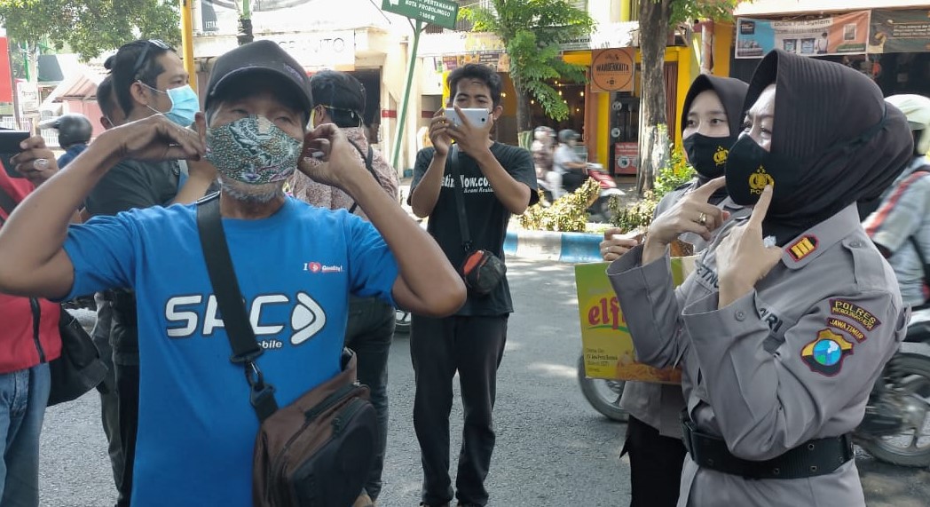 Polwan dari Polresta Probolinggo membagikan masker bermotif batik pada Hari Batik Nasional. (Foto: Ikhsan Mahmudi/Ngopibareng.id)
