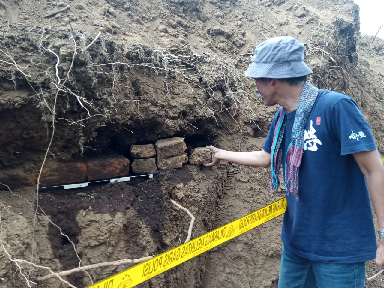 Arkeolog dari Universitas Negeri Malang (UM), Dwi Cahyono saat mengukur dimensi struktur bata kuno di Dusun Ngenep, Karangploso, Malang (Foto: Lalu Theo/Ngopibareng.id)