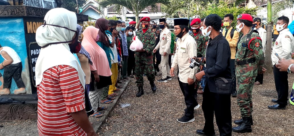 Kader GP Ansor dan Pemuda Muhammadiyah Banyuwangi saat membagikan sembako bagi kaum miskin. (Foto: istimewa)